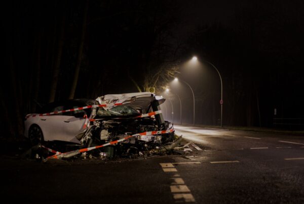 A wrecked car after a crash on a dimly lit street in Berlin at night.
